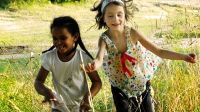 Zwei Kinder spielen ausgelassen im Freien